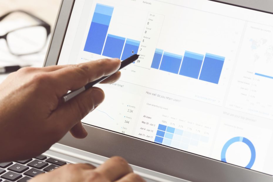 Analyst pointing at retention and cohort analysis dashboard on a screen